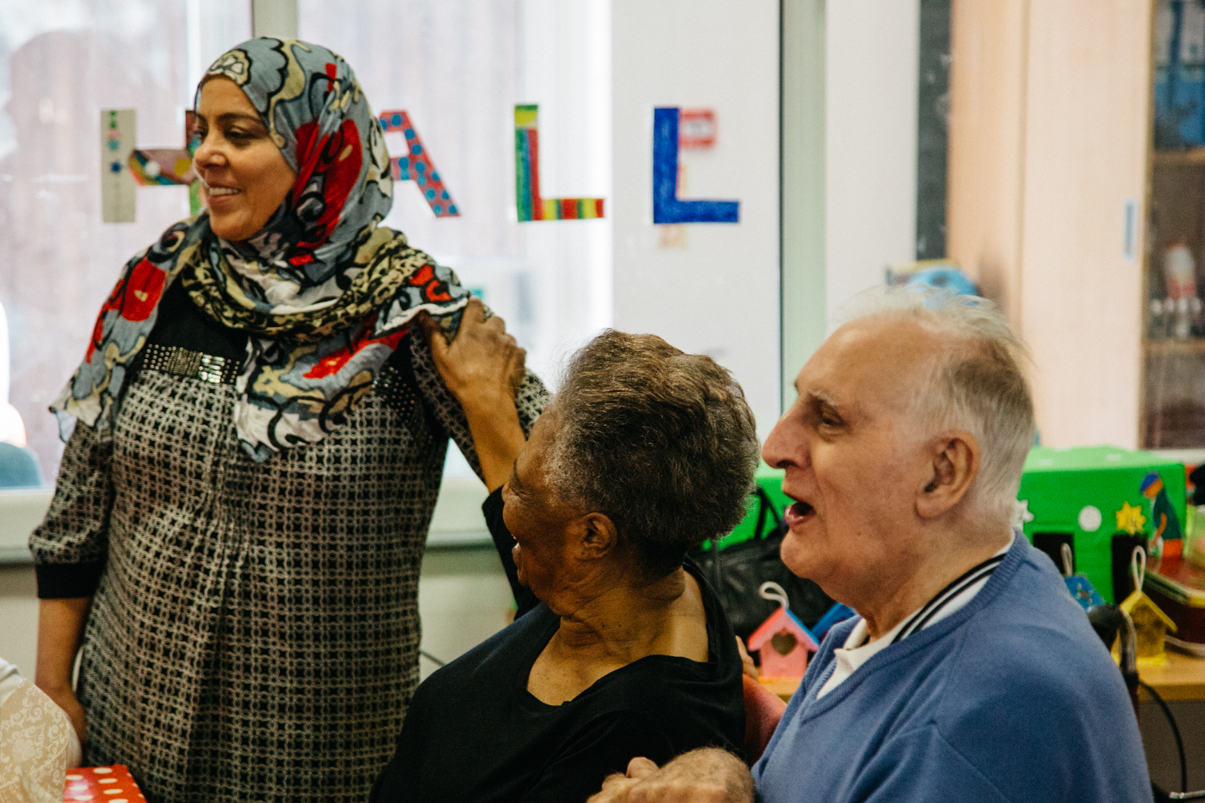 Carer chatting with two older people at a community activity