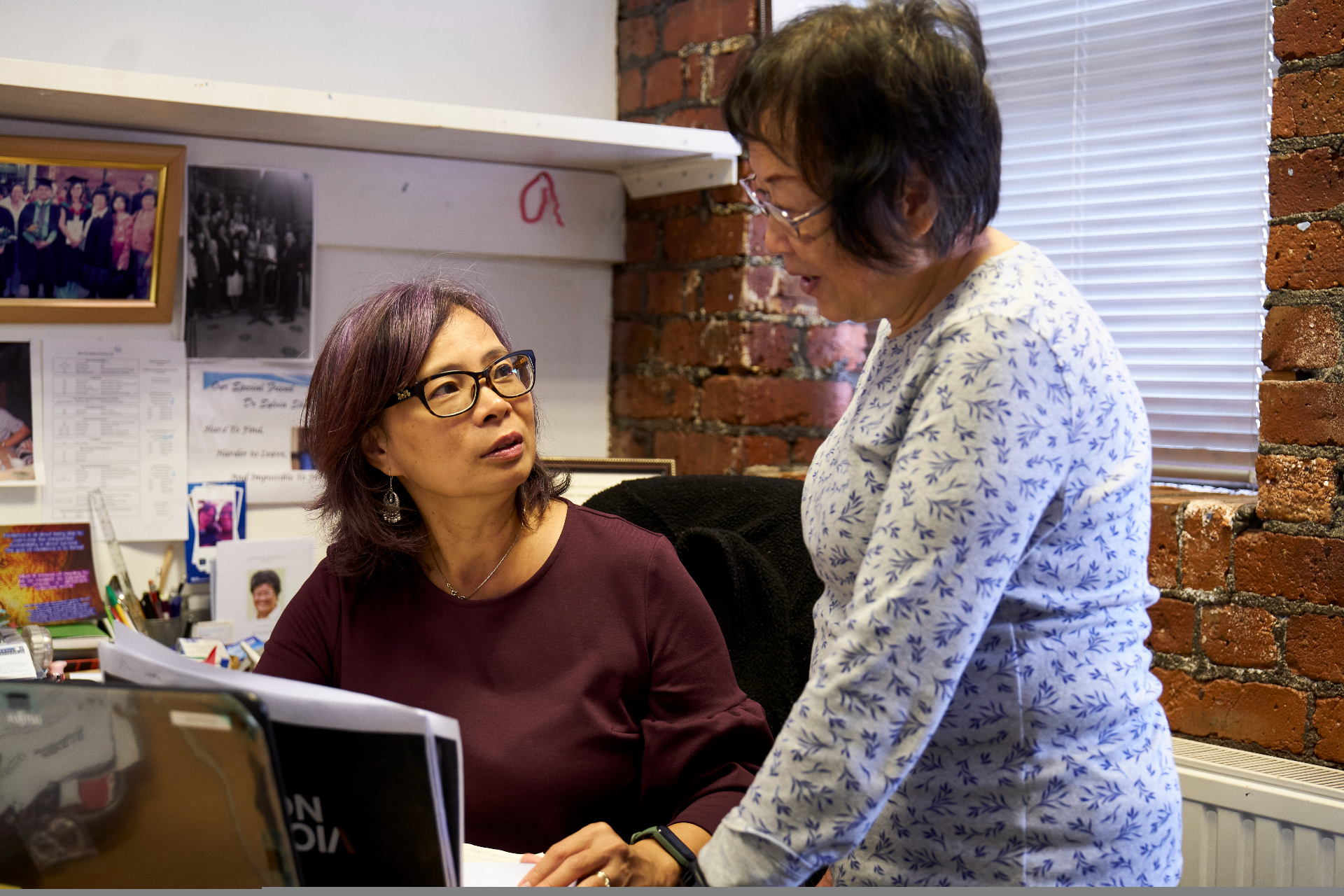 An advisor talking with an older woman at a desk during a guidance session