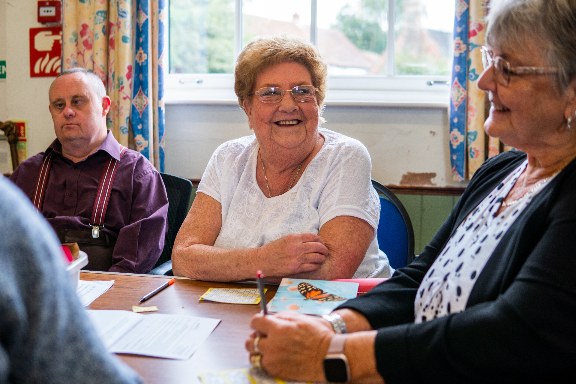 Older people chatting and smiling around a table
