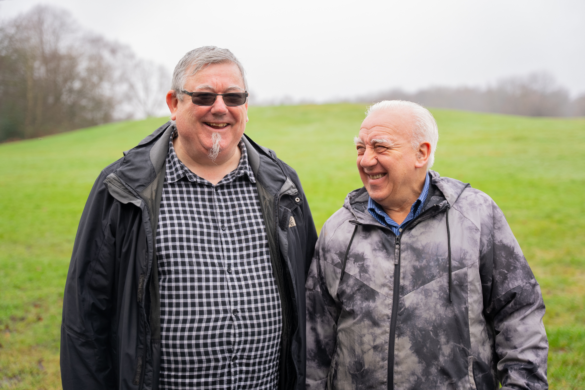Two older men smiling together outdoors