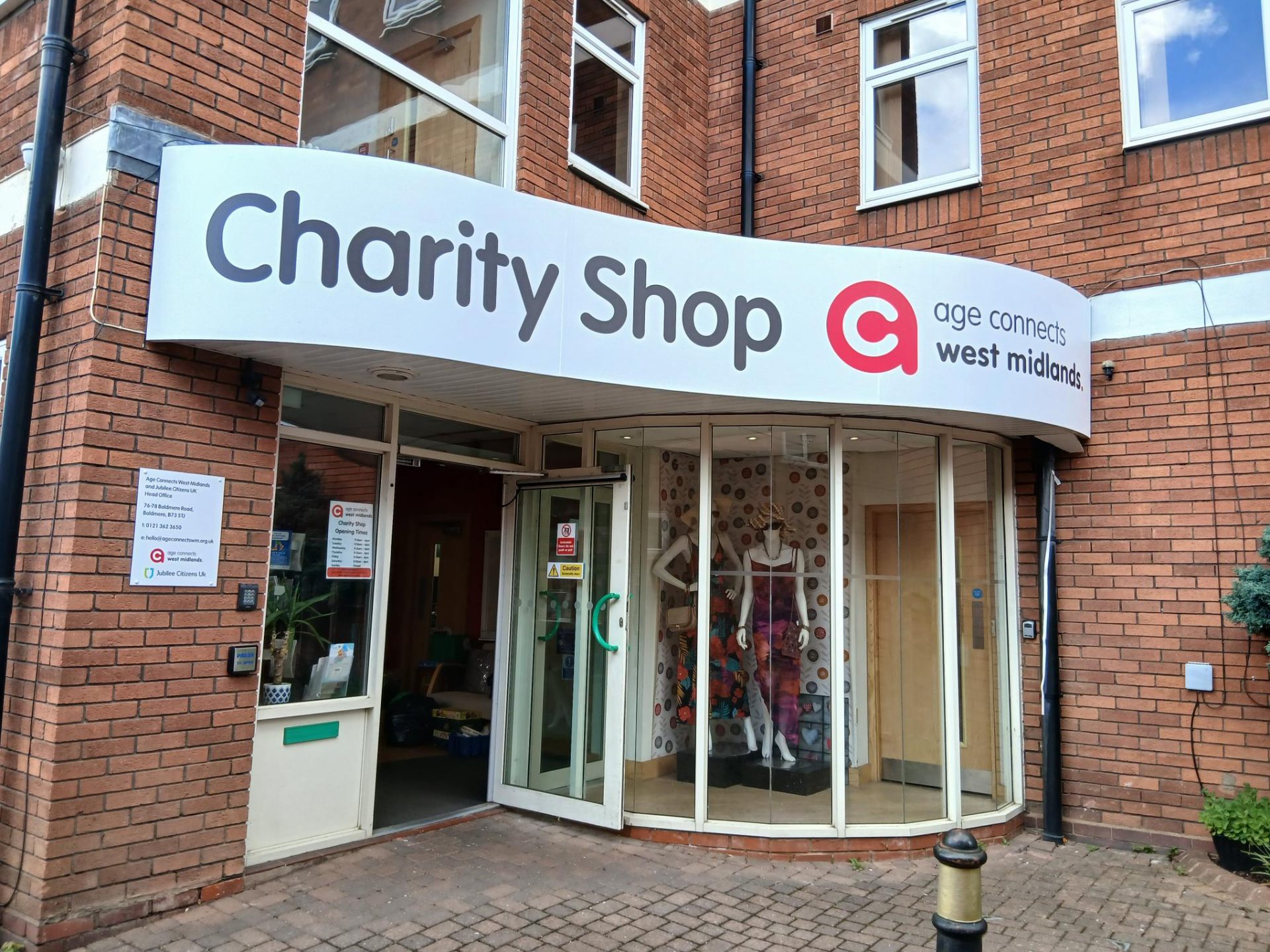 The Boldmere Charity Shop front entrance with large curved sign and display windows
