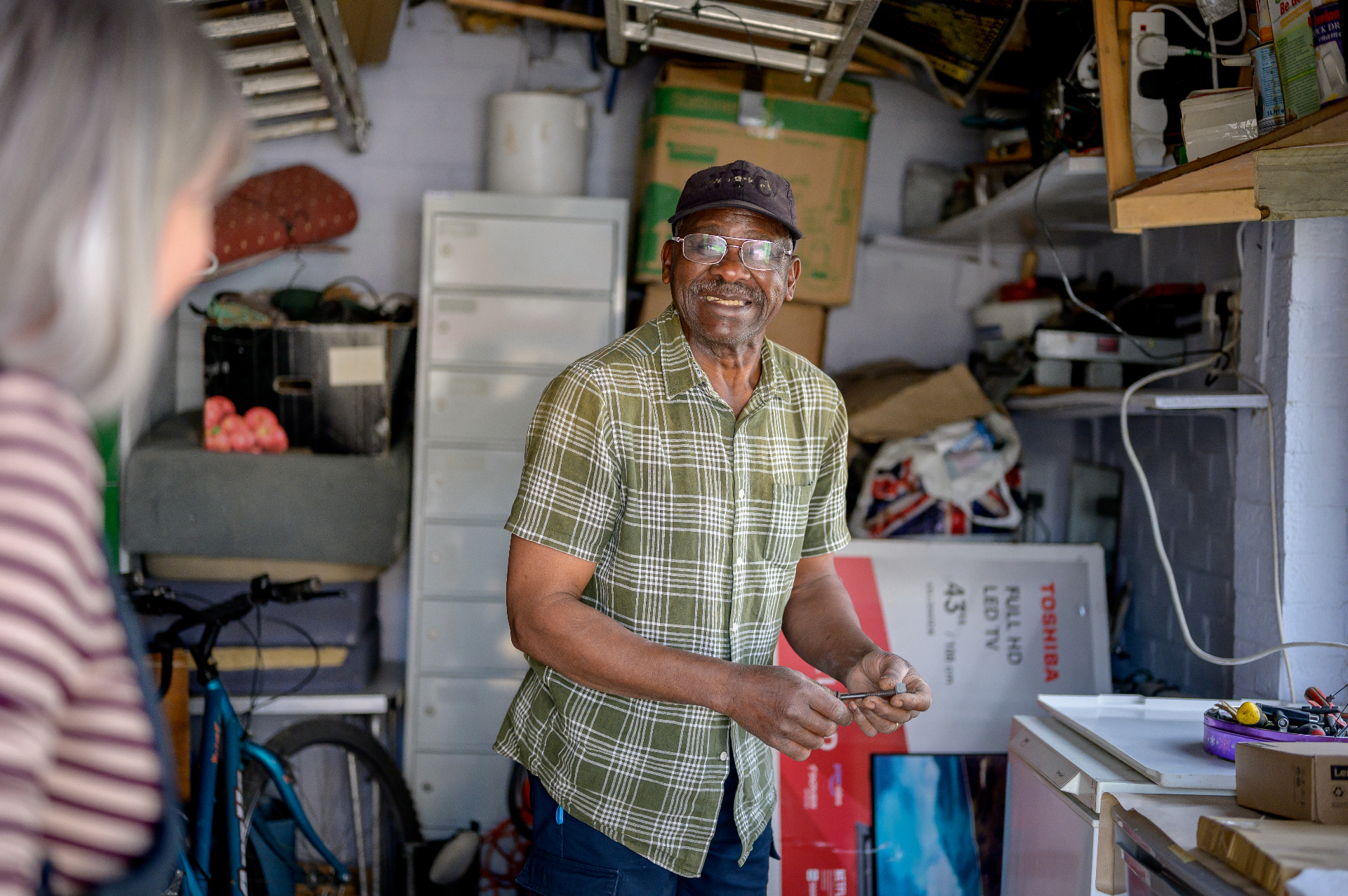 Man smiling during a home visit in a garage workspace