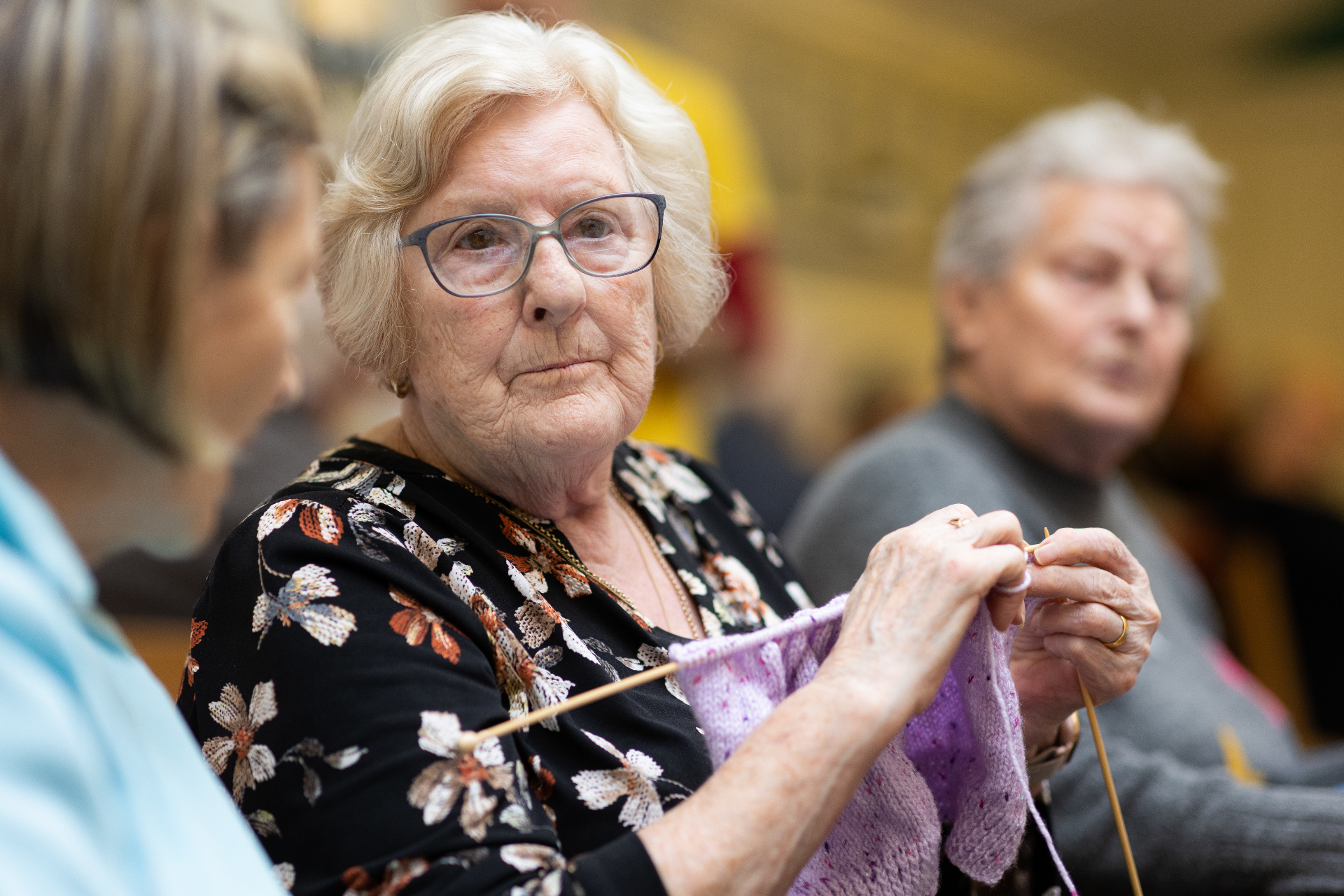 Older woman knitting at a community group