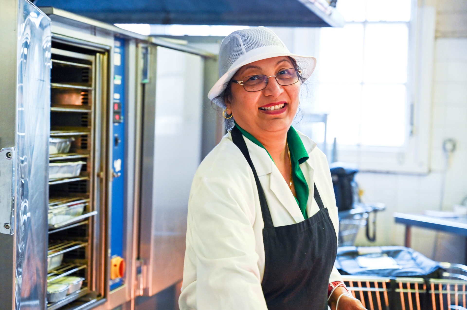 A smiling community kitchen volunteer