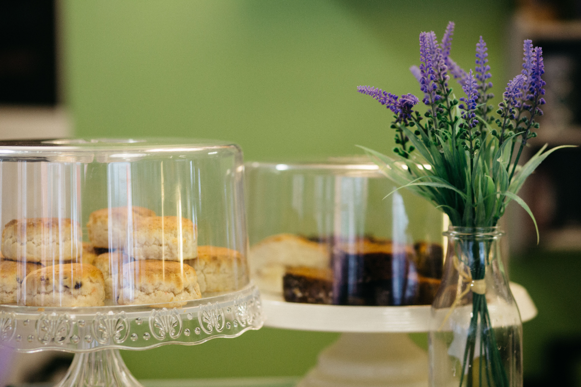 Fresh scones and cakes displayed in Communitea Café beside a vase of lavender