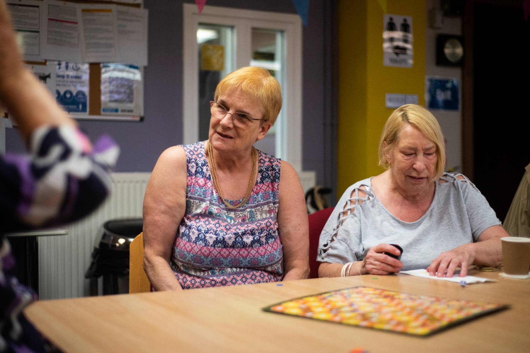 Members playing a board game together at a day centre table