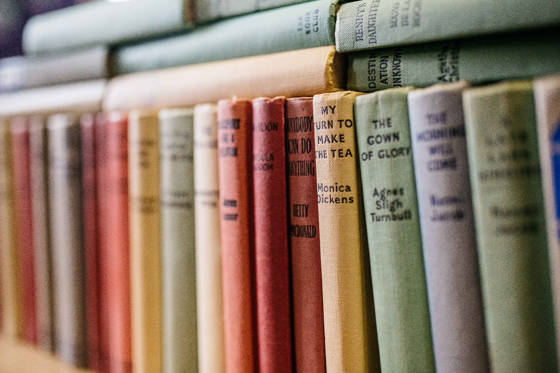 A row of vintage hardback books on a shelf in the charity shop